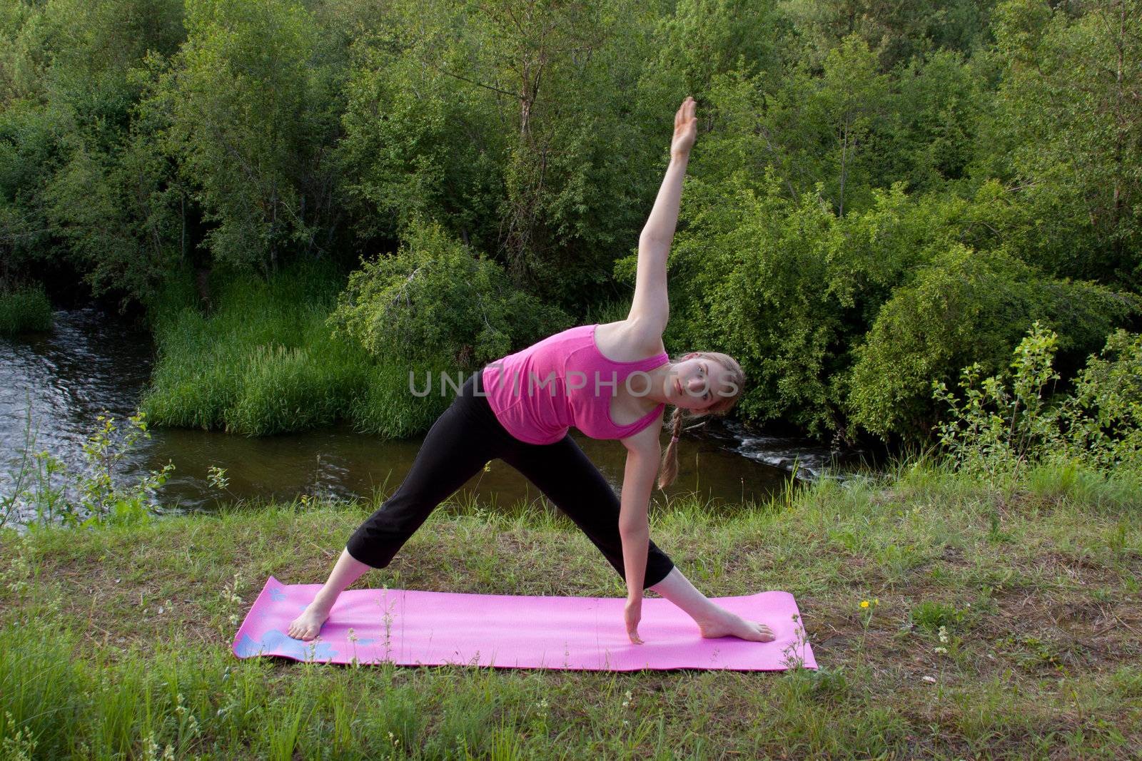 Pretty young woman doing Yoga at sunset.