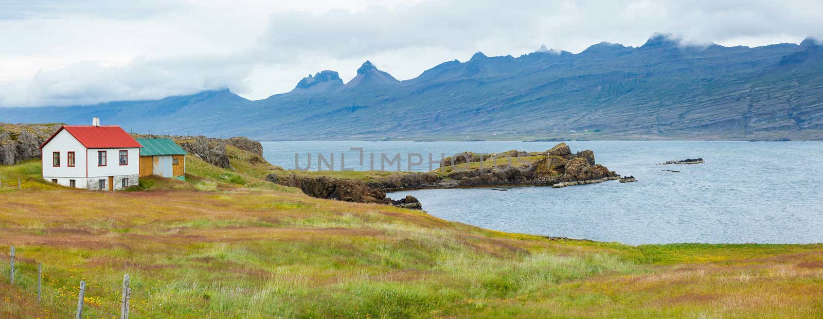 Rural beautiful summer landscape - fjord, house, mountains. Iceland. Panorama.