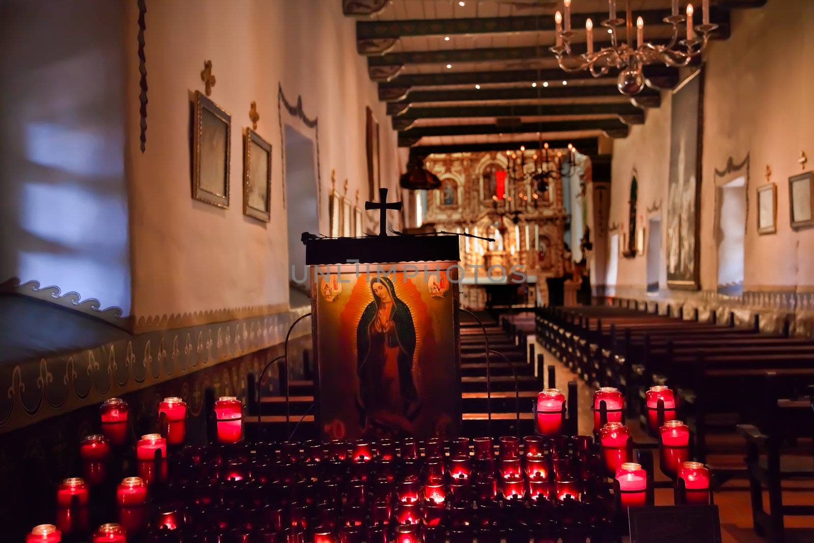 Guadalupe Shrine Red Candles Mission San Juan Capistrano Church California.  Father Junipero Serra founded the Mission in 1775 and church was destroyed in 1812 by earthquake.  Guadalupe is from the Guadalupe Shrine and Painting in Mexico.