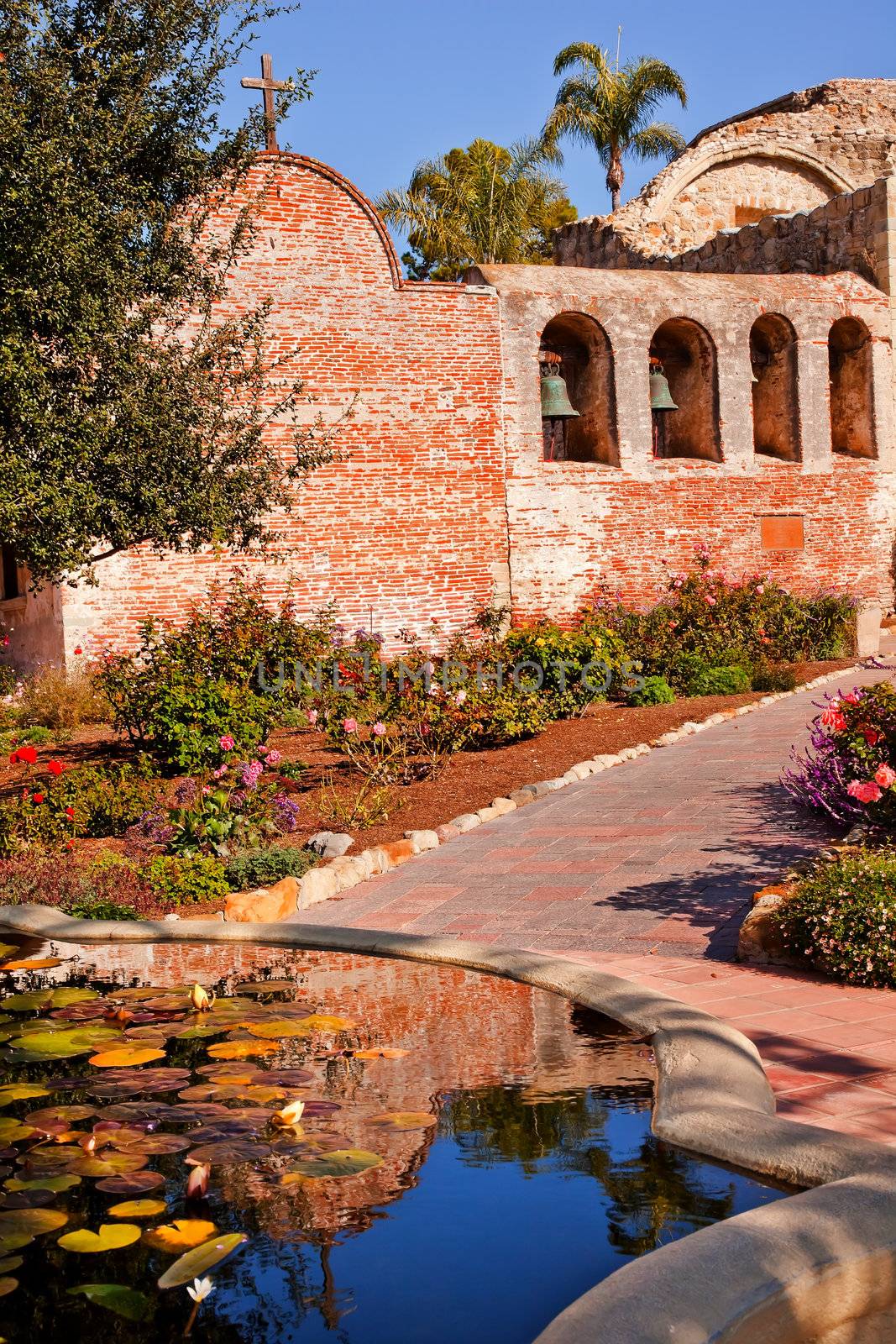 Fountain Pool Bells Mission San Juan Capistrano Church Rose Gardens and Ruins in California.  Father Junipero Serra founded the Mission in 1775.  Mission bells in the back.  The church was destroyed in 1812 by earthquake.