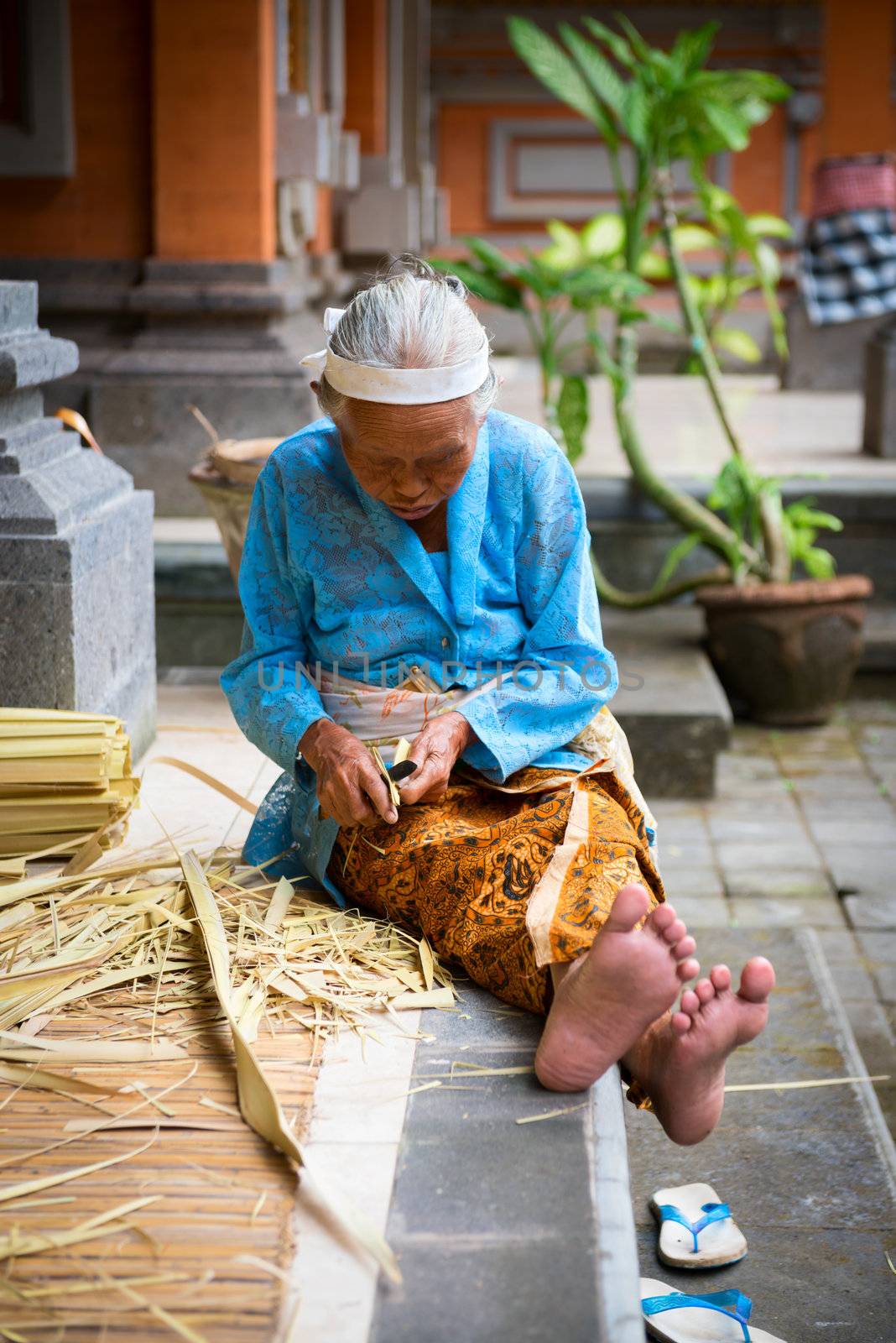 Balinese old women make baskets for offerings by iryna_rasko