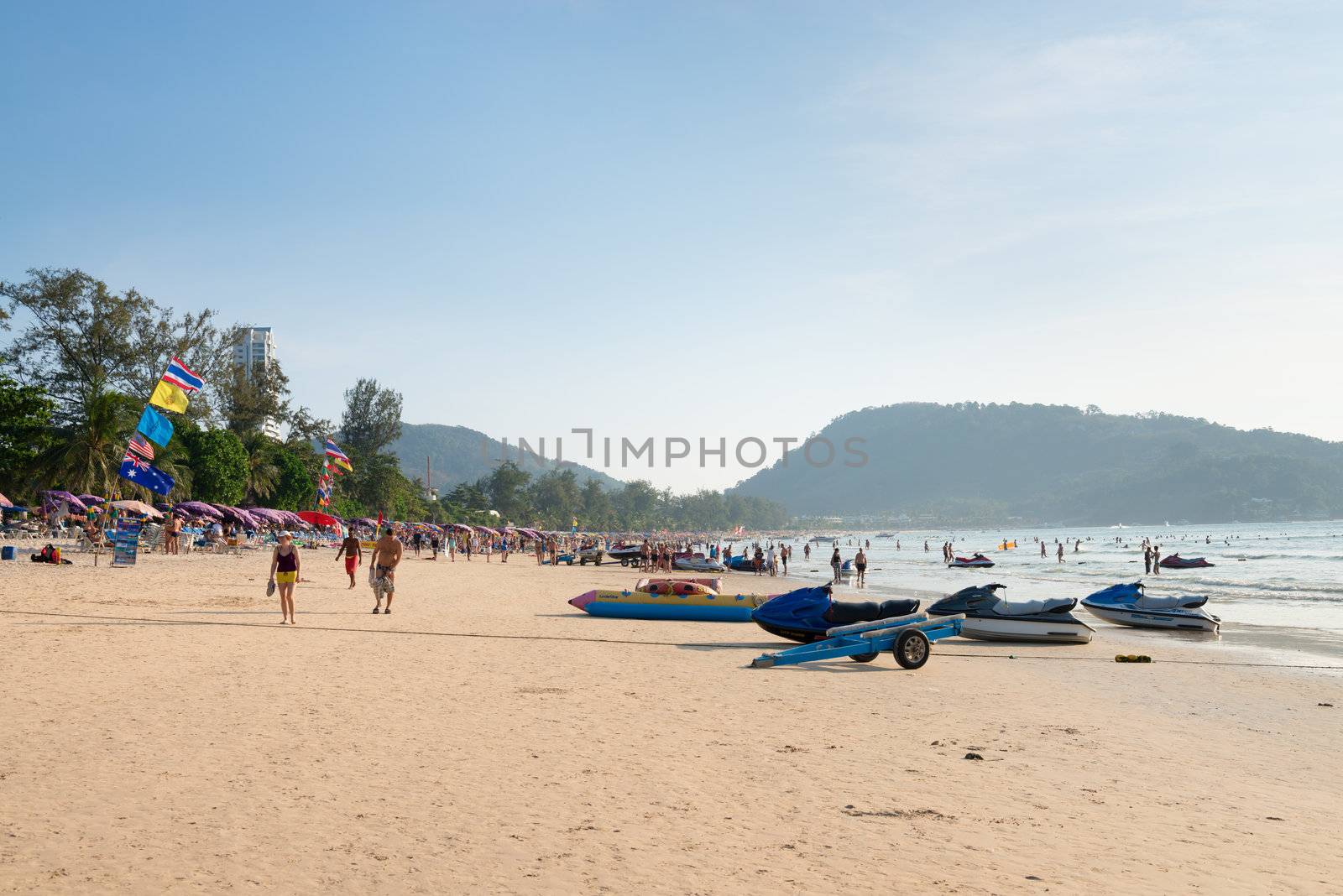 PHUKET, THAILAND - Jan 28: Patong beach with tourists and water scooters on Jan 28, 2013 in Phuket, Thailand. Phuket is a famous winter destination for thousands of tourists. 