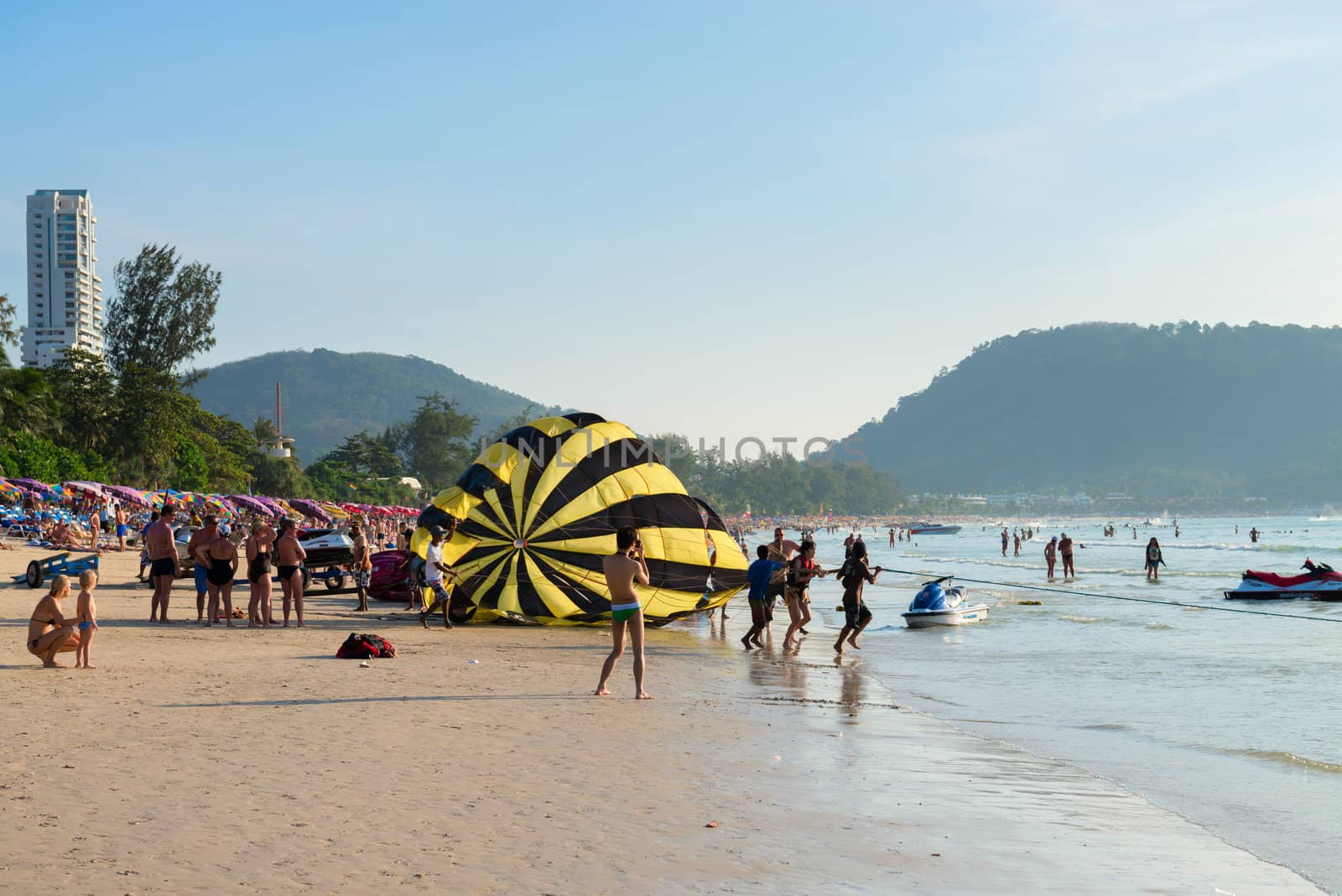 PHUKET, THAILAND - Jan 28: Crowded Patong beach with tourists on Jan 28, 2013 in Phuket, Thailand. Phuket is a famous winter destination for thousands of tourists. 