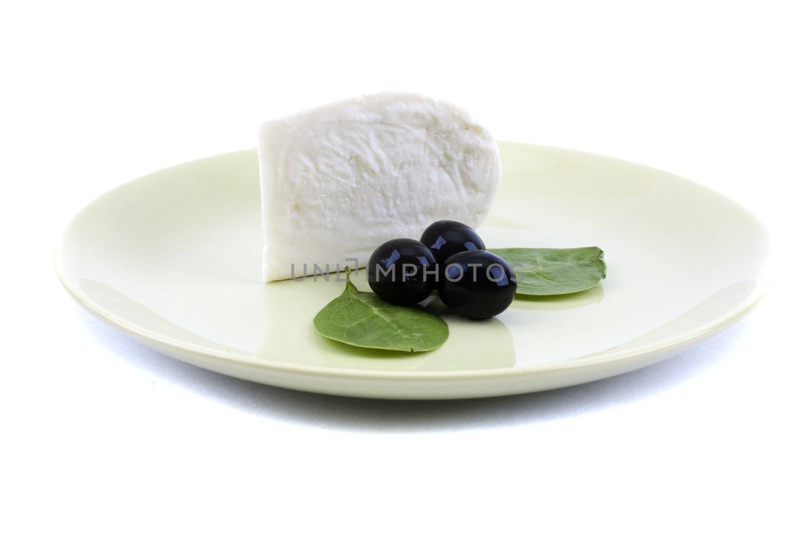 cheese and spinach on a green plate with olive