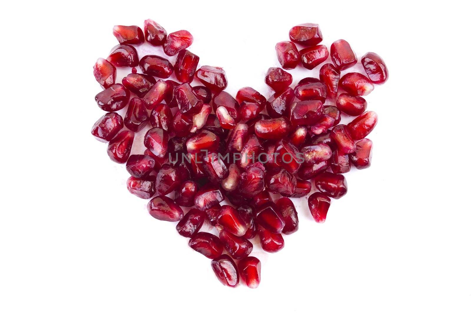 pomegranate seeds in heart shape isolated by Triphka