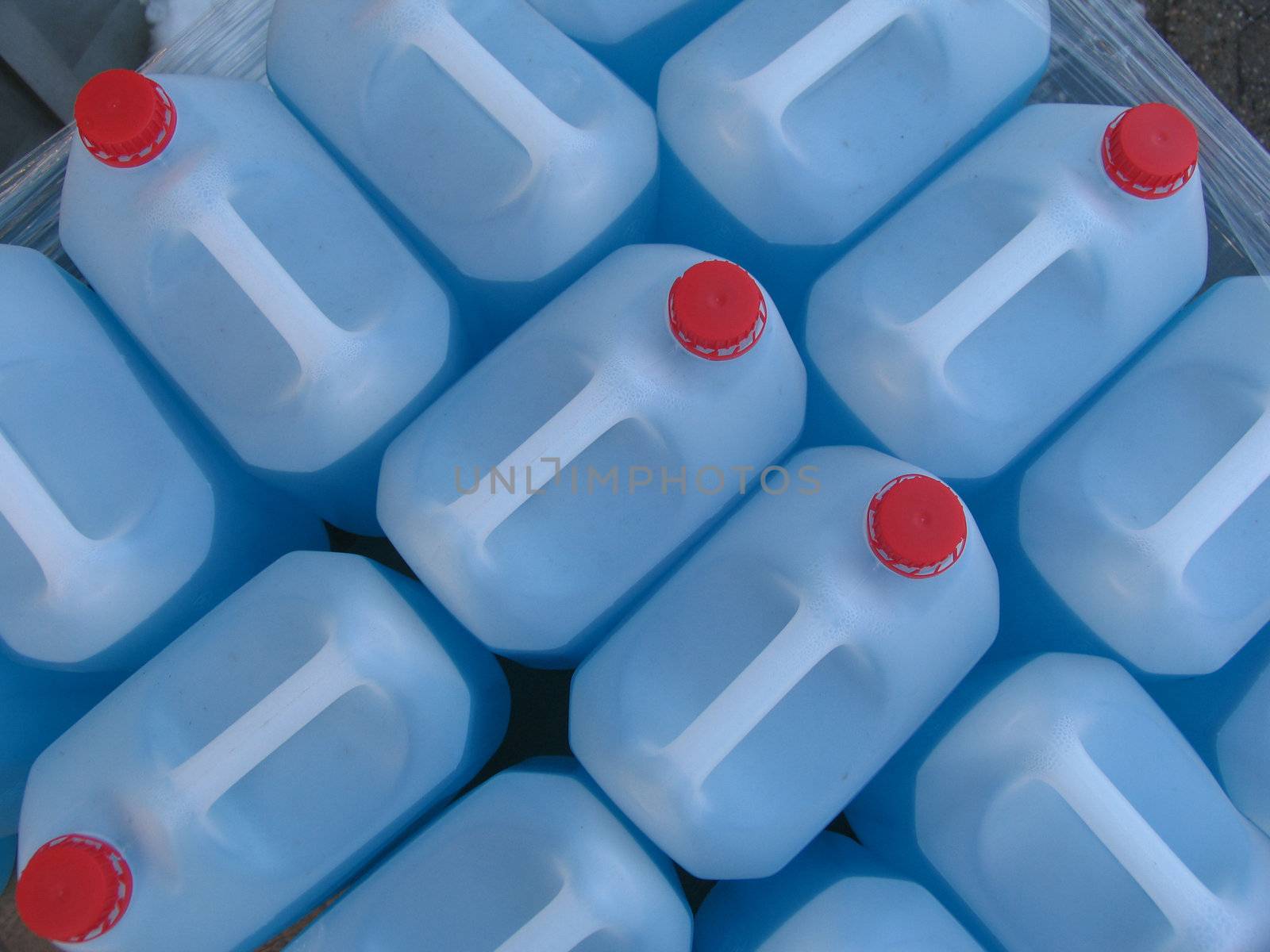 Plastic containers with blue liquid. Windshield washer fluid (water and alcohol) for winter use in Scandinavia. 
