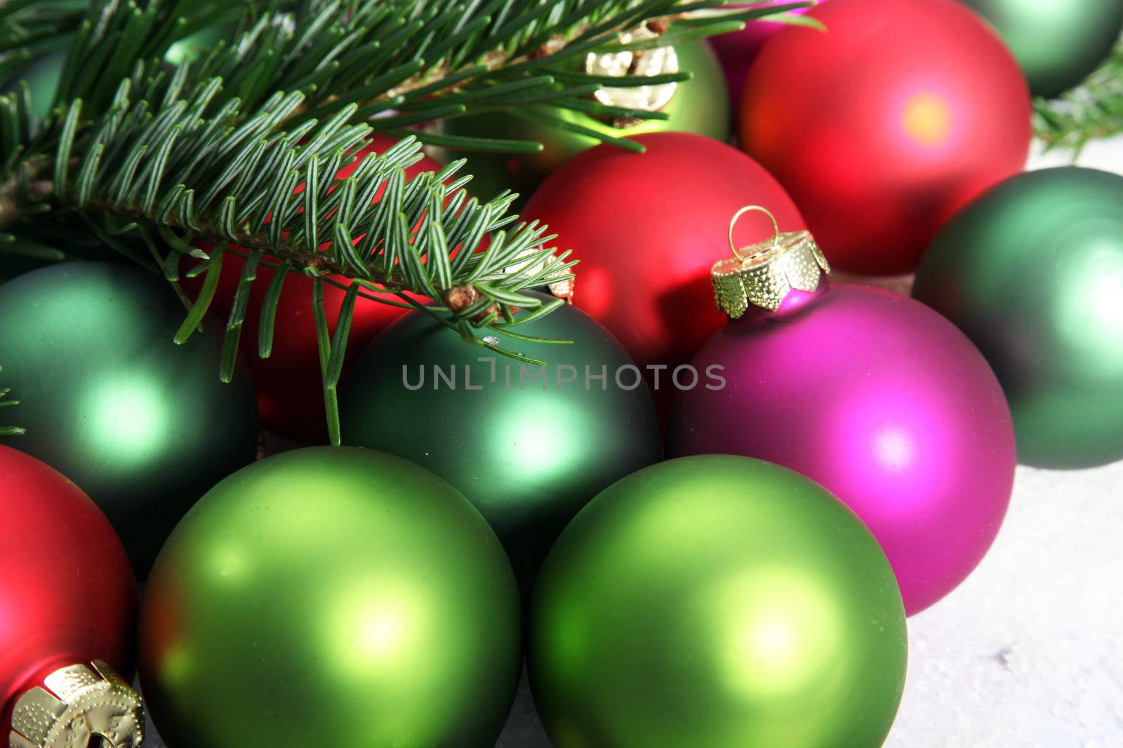 Close-up of a myriad of colorful Christmas baubles and pine needles