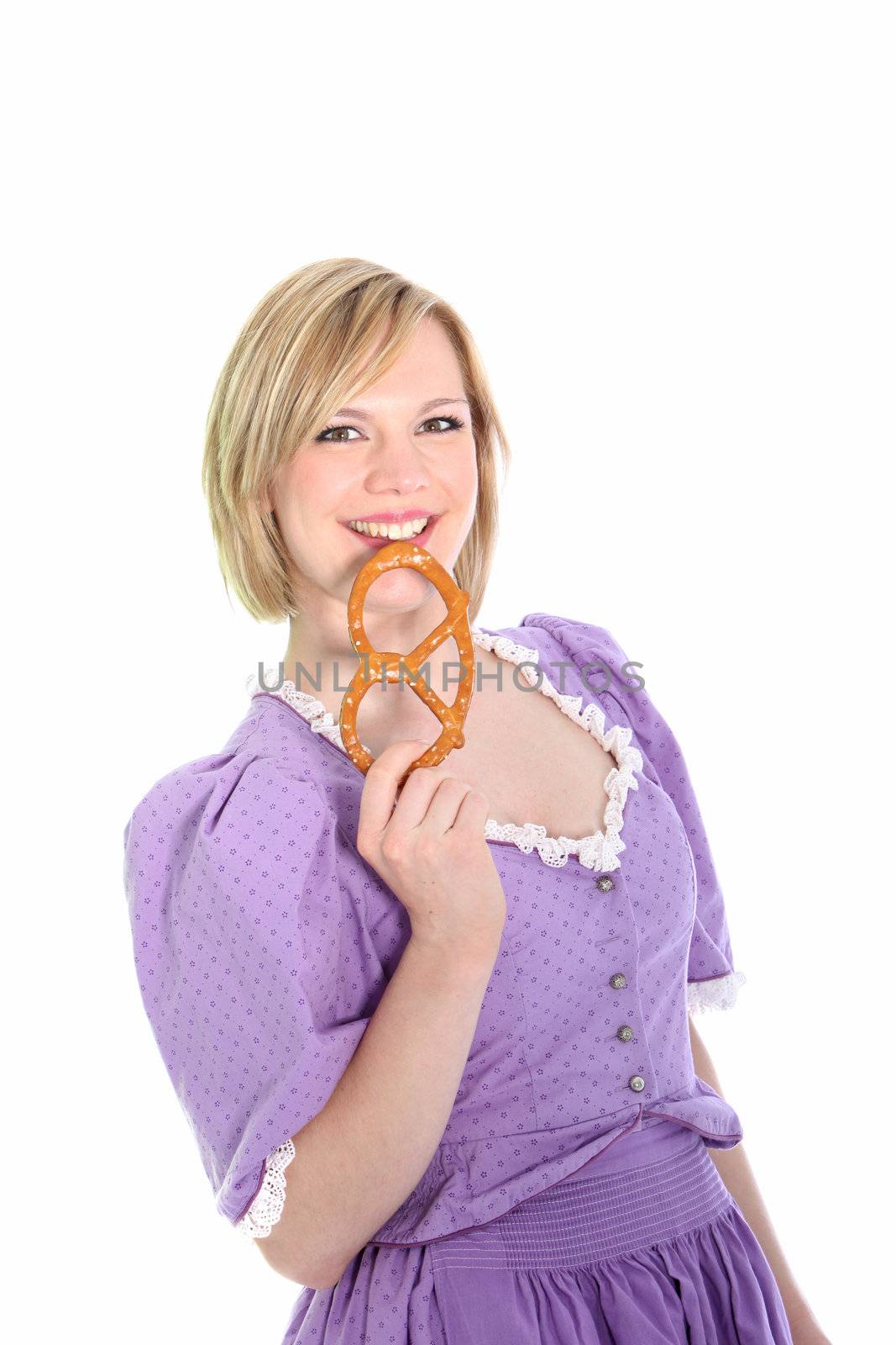 Portrait of a blond in a lavender dirndl dress and holding a bretzel. On white