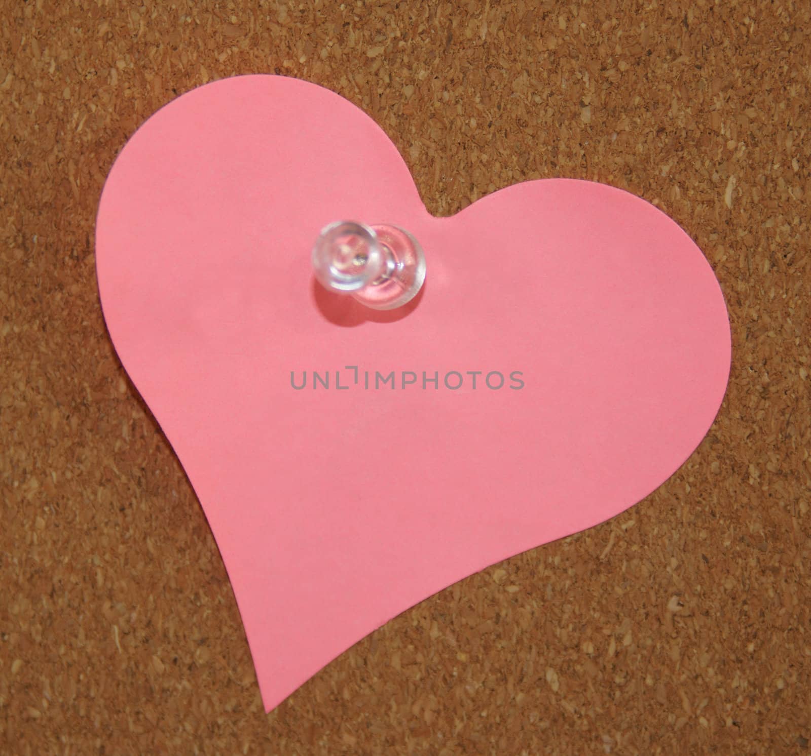 A heart shade sticker is pinned on a cork board