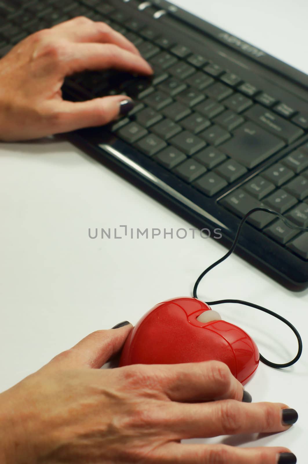 A lady holds a heart shaped mouse for on-line dating