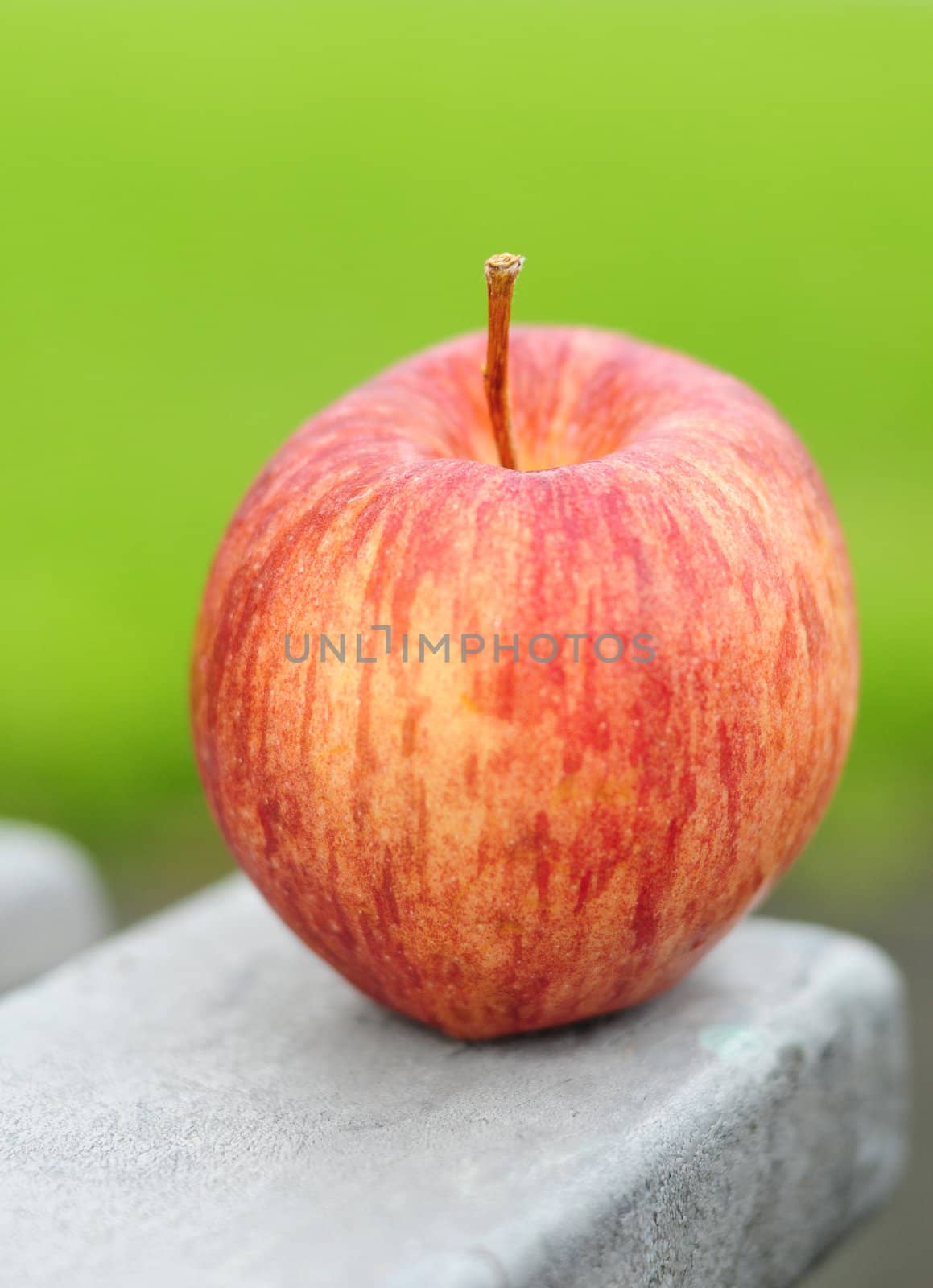 Delicious red organic apple with green background