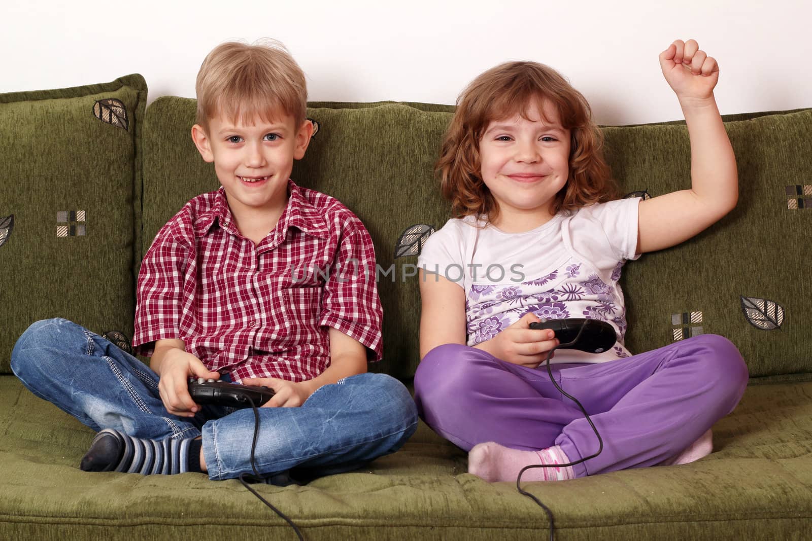 little girl and boy play video game by goce