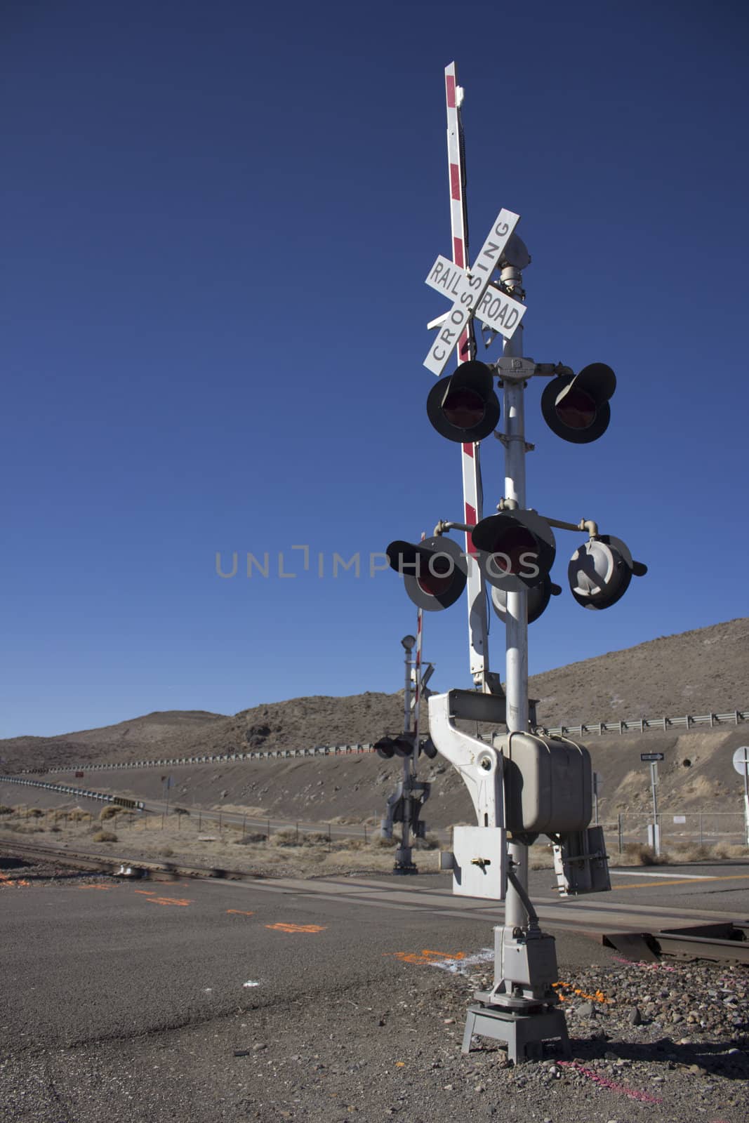 rail road crossing signal with blue skies in the desert.