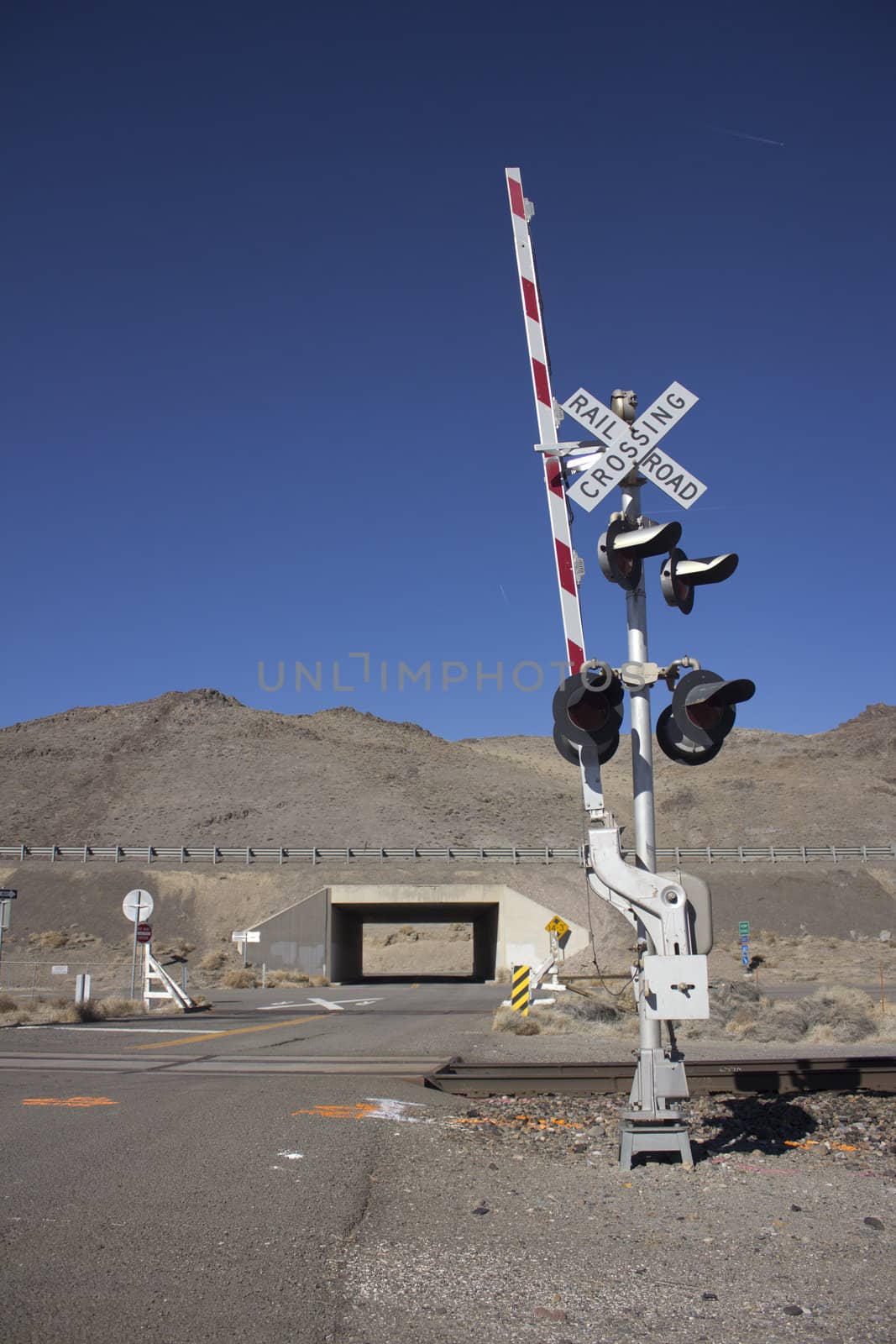 rail road crossing signal with blue skies in the desert.