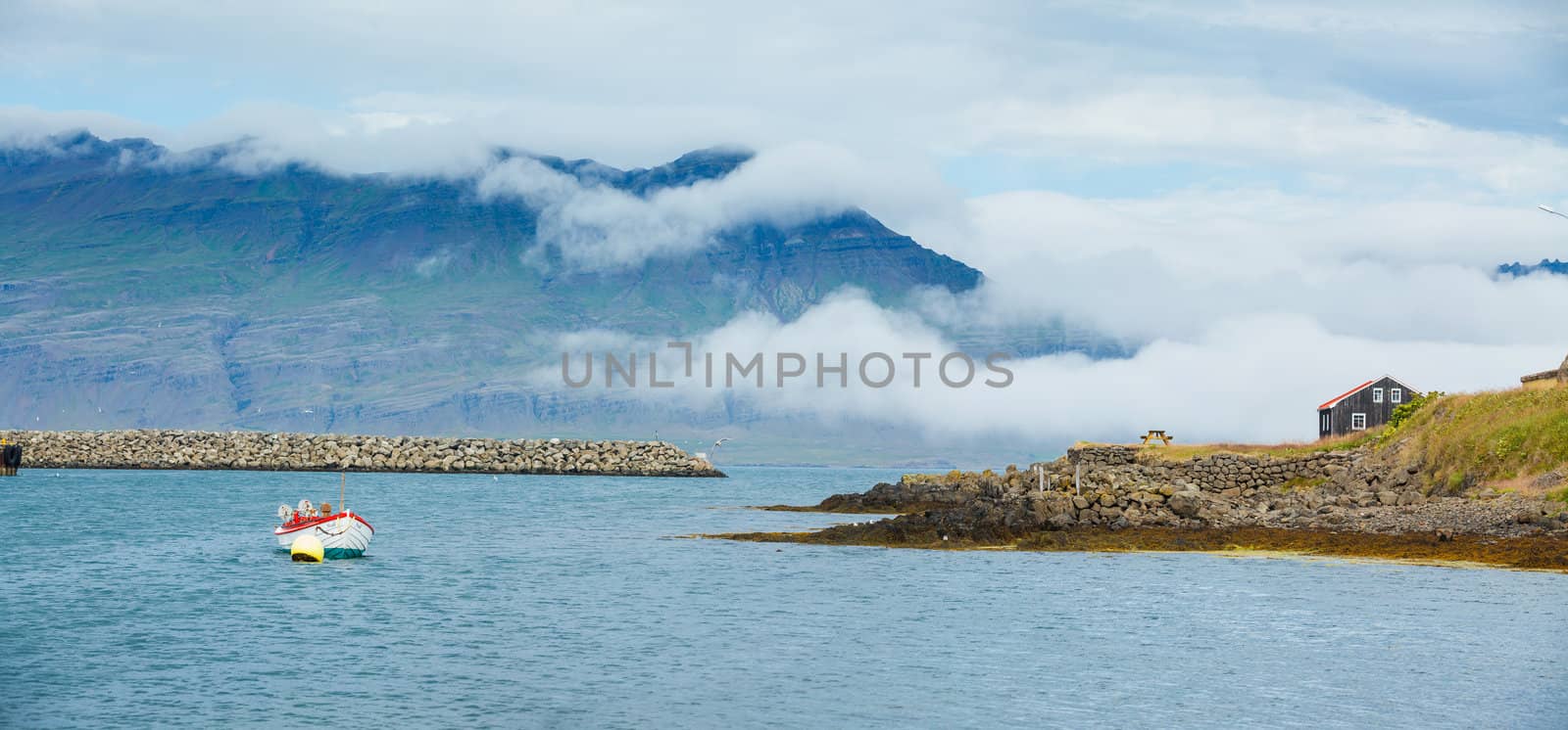 Rural beautiful summer landscape - fjord, boat, mountains. Iceland. Panorama.