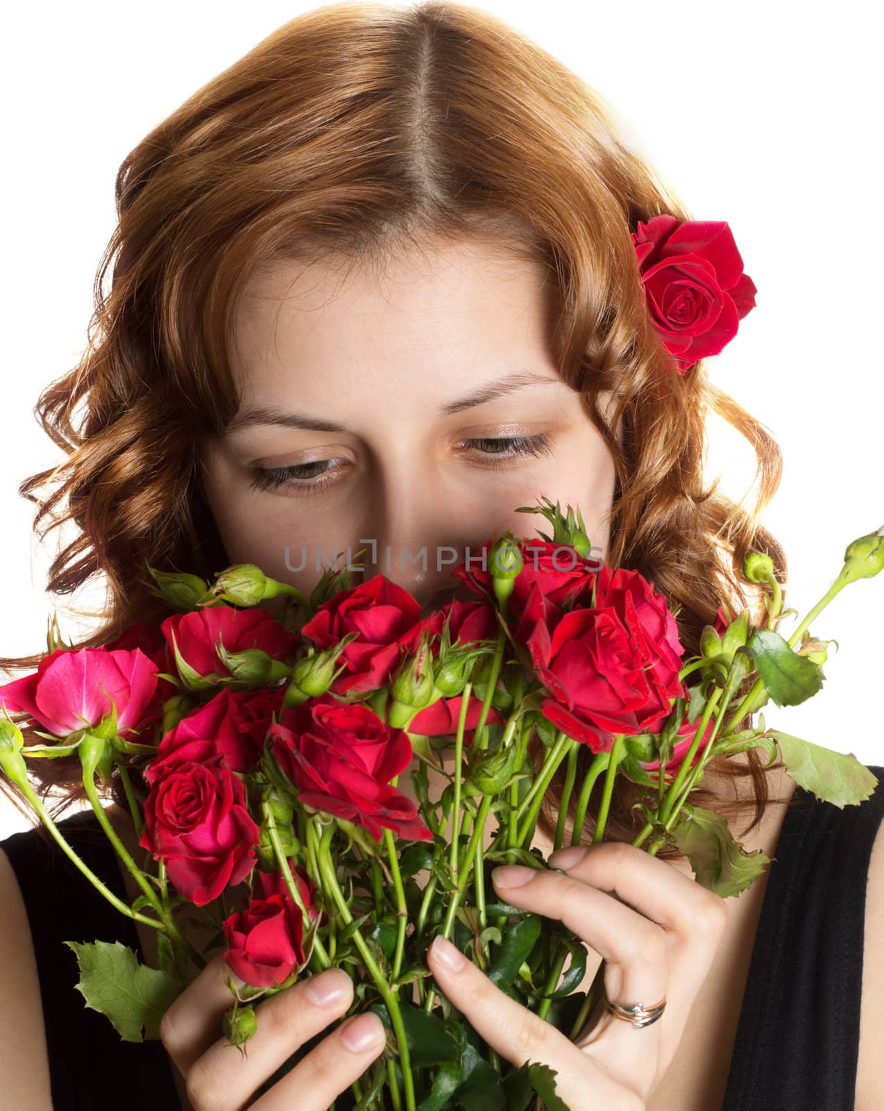 Pretty girl smelling roses on a white background isolated