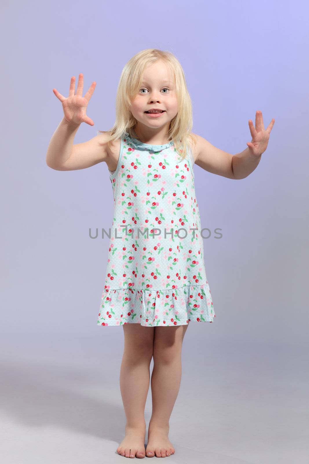 cute little blond girl posing against blue background