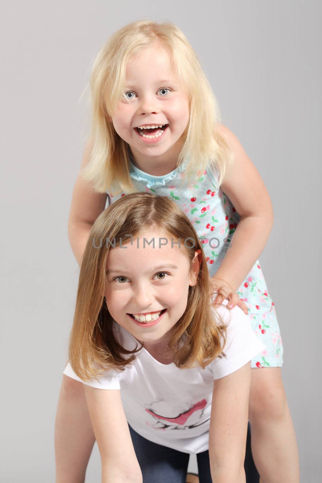 two cute little blond girls having fun