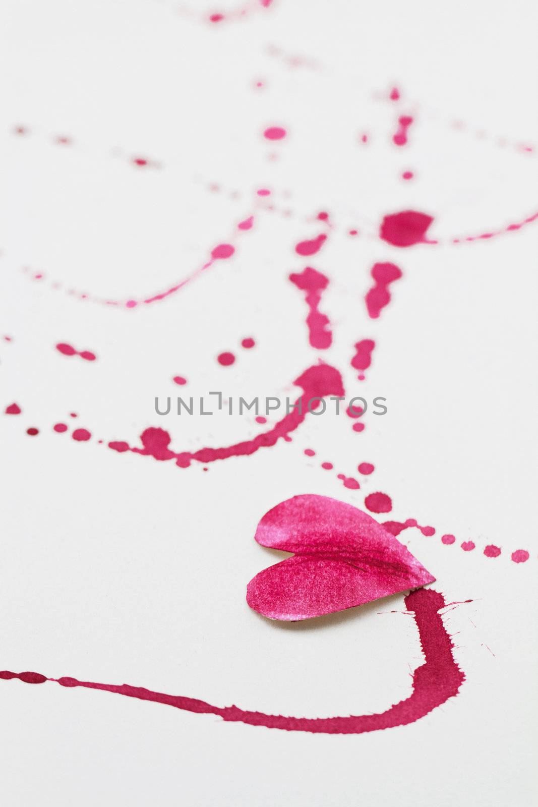White background with a paper heart and red splashes