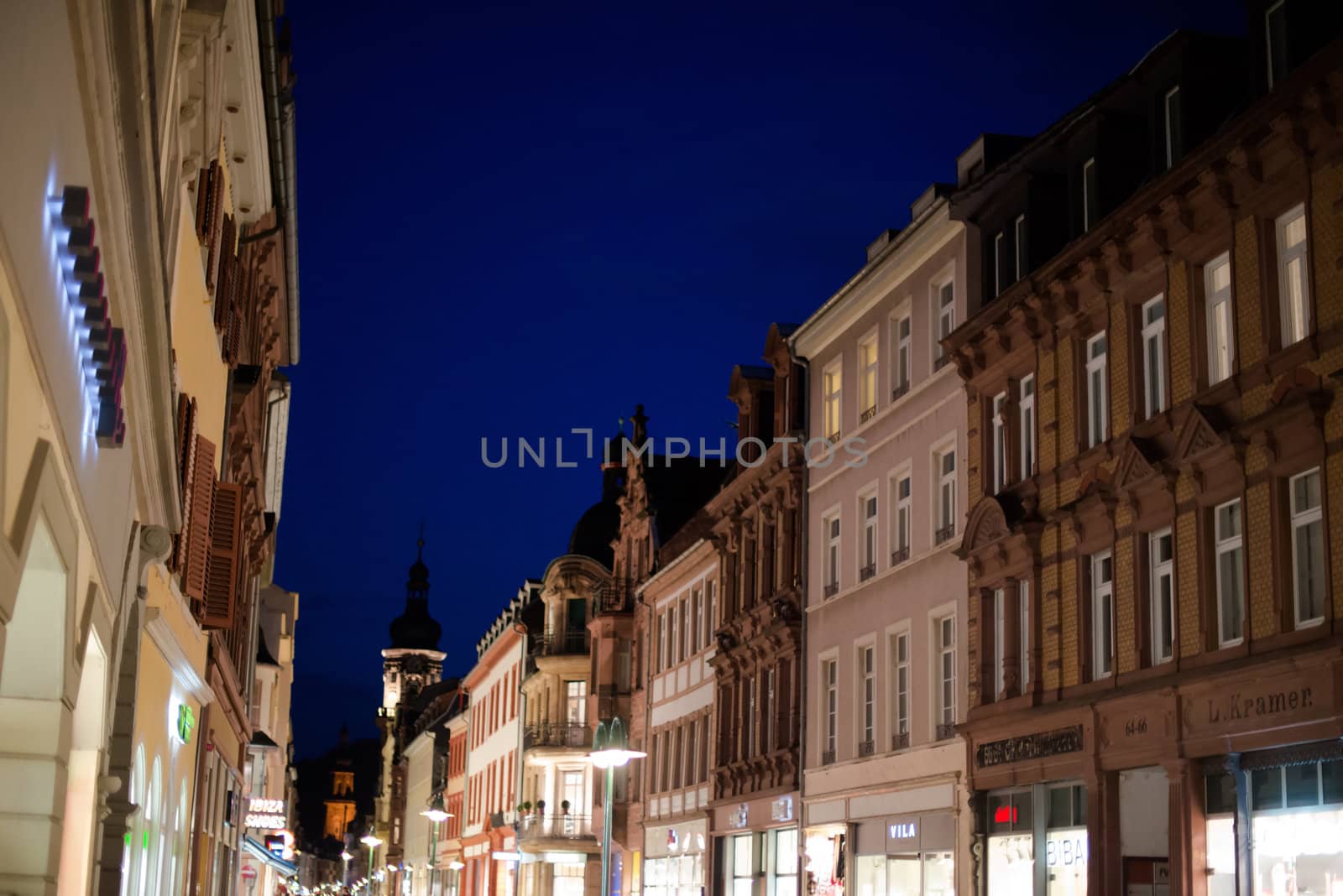 Heidelberg, Germany - February 2, 2013: Tourists walking through the centre of Heidelberg, Germany with its beautiful medieval houses in the evening of February 2, 2013. Heidelberg is a well-known tourist attraction due to its old history and beautiful location at the Neckar river.