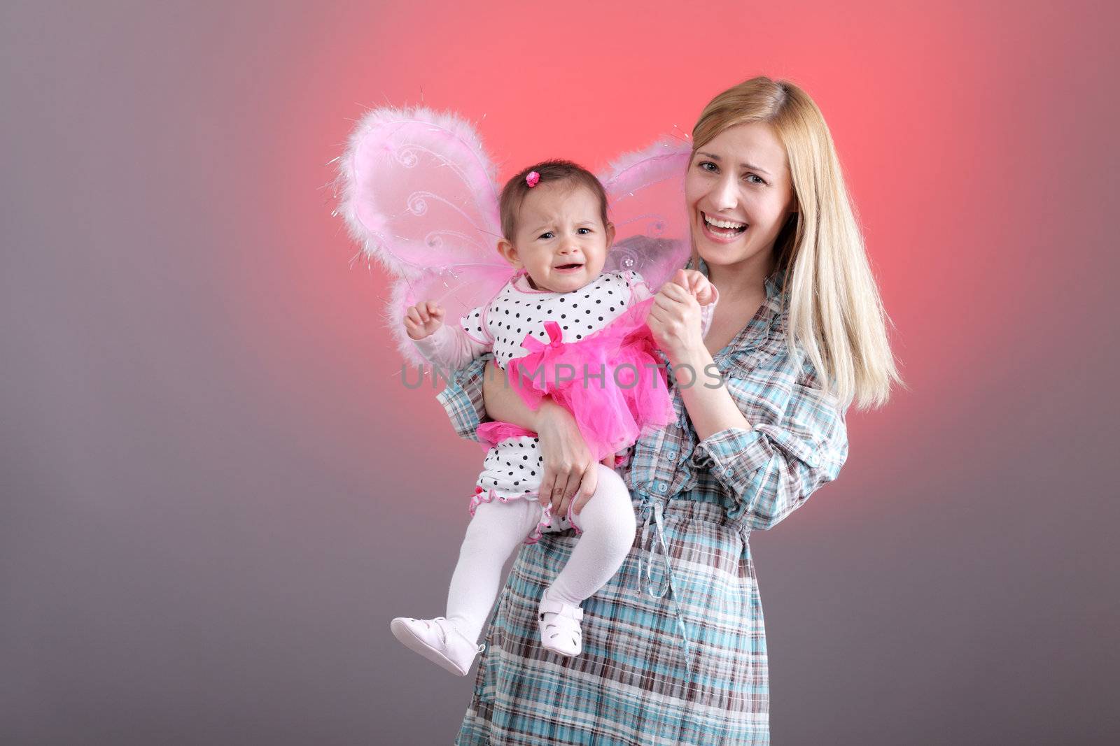 mother and daughter with funny expressions on pink background