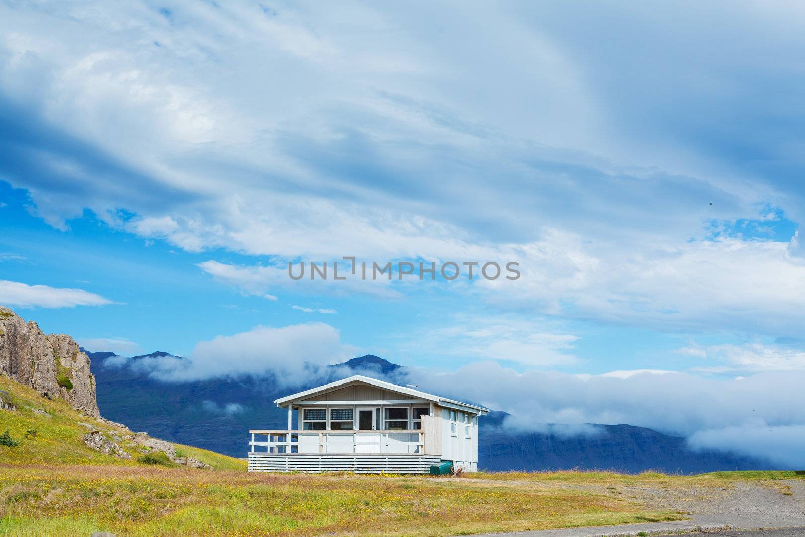 Beautiful house in Iceland. Mountains in background.