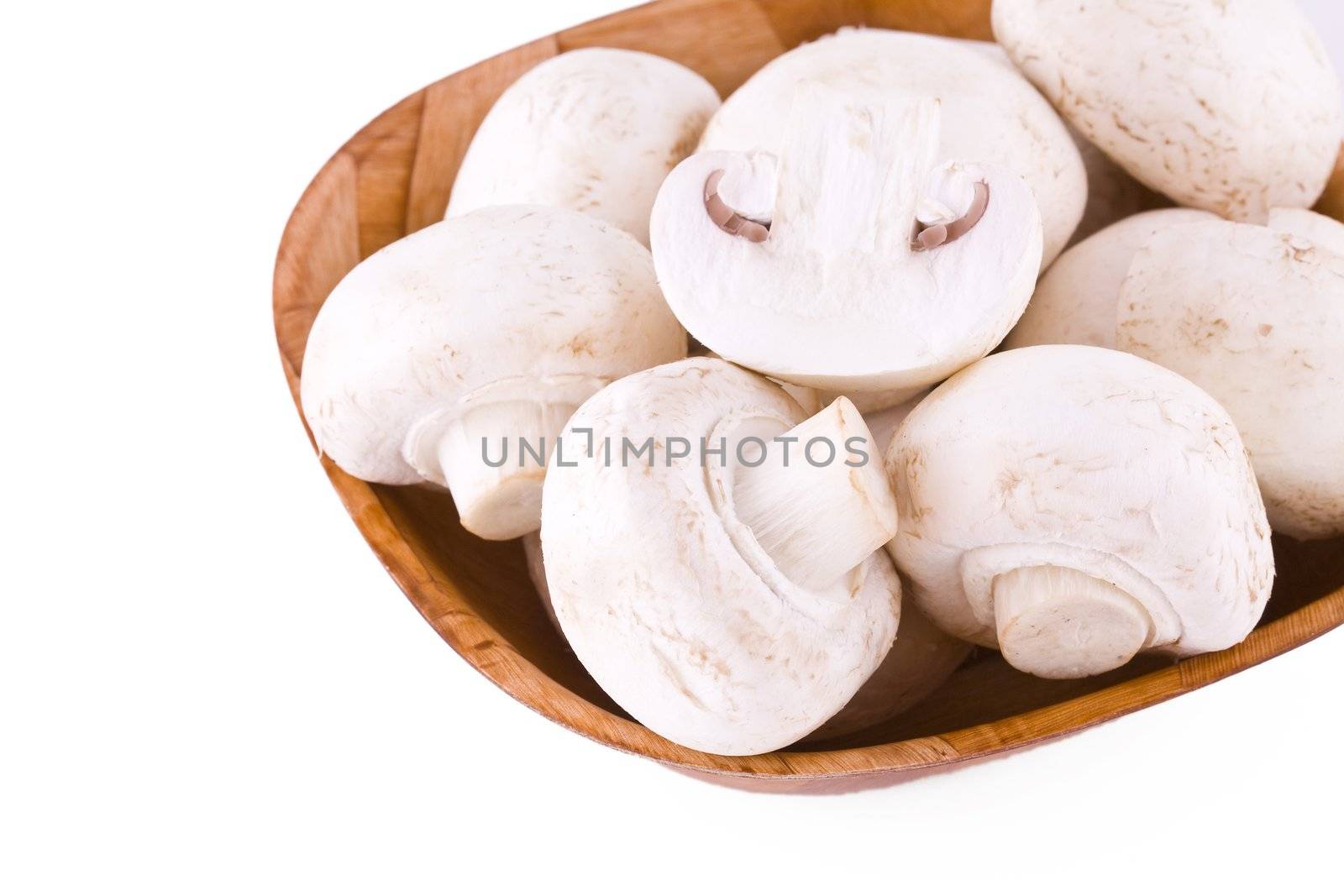 Fresh mushrooms in a wooden bowl isolated on white