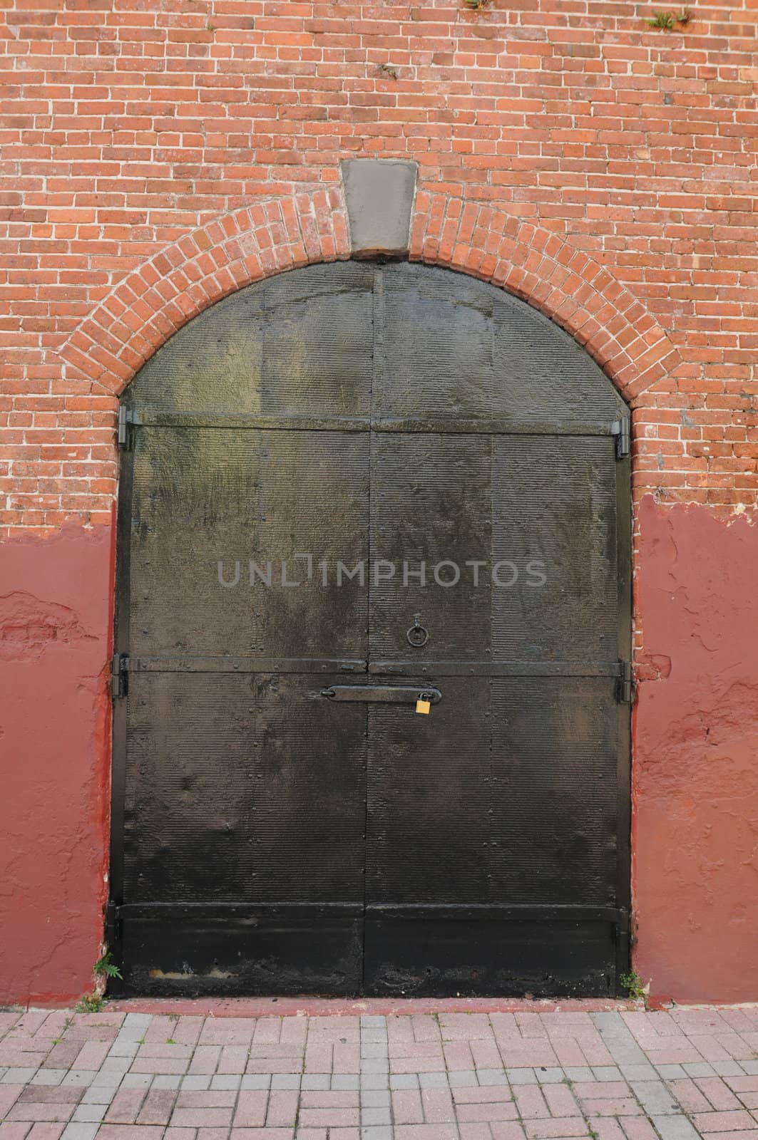 red brick building with black doors with padlock to keep out