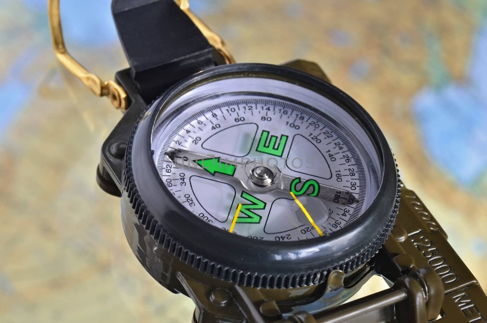 Military style compass on out of focus map background