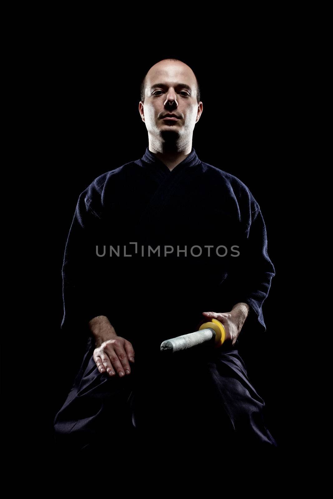 portrait of a kendo fighter with shinai, against black backgroung