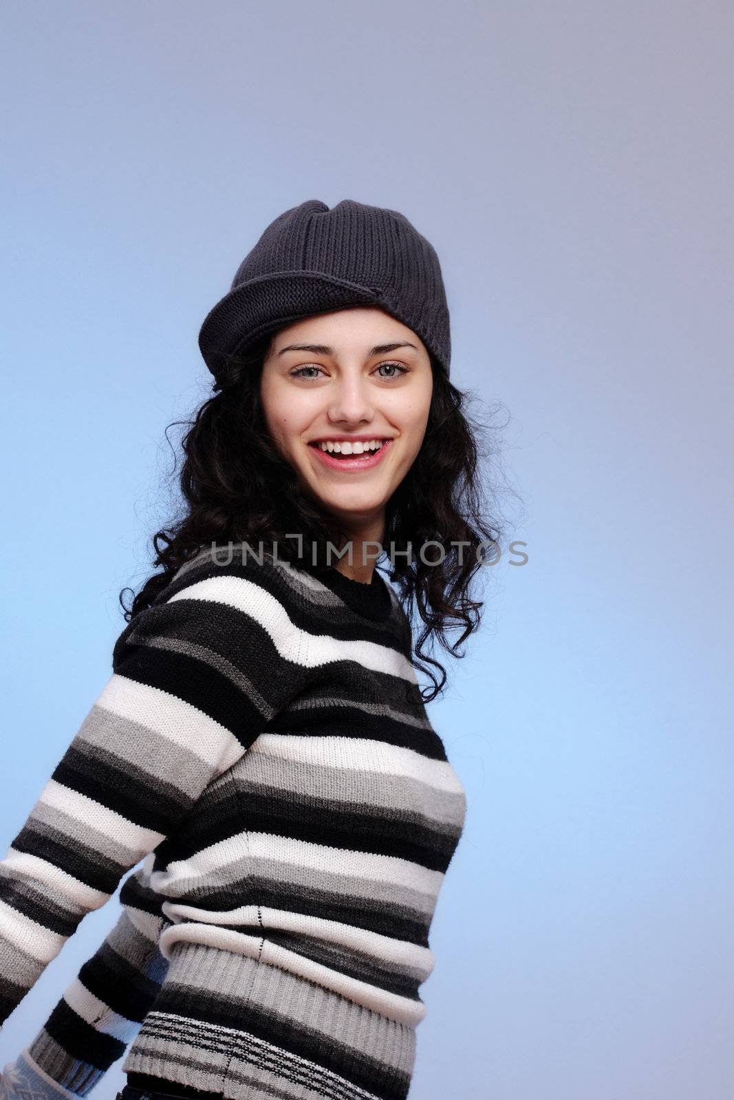 portrait of a beautiful young girl smiling, on blue background