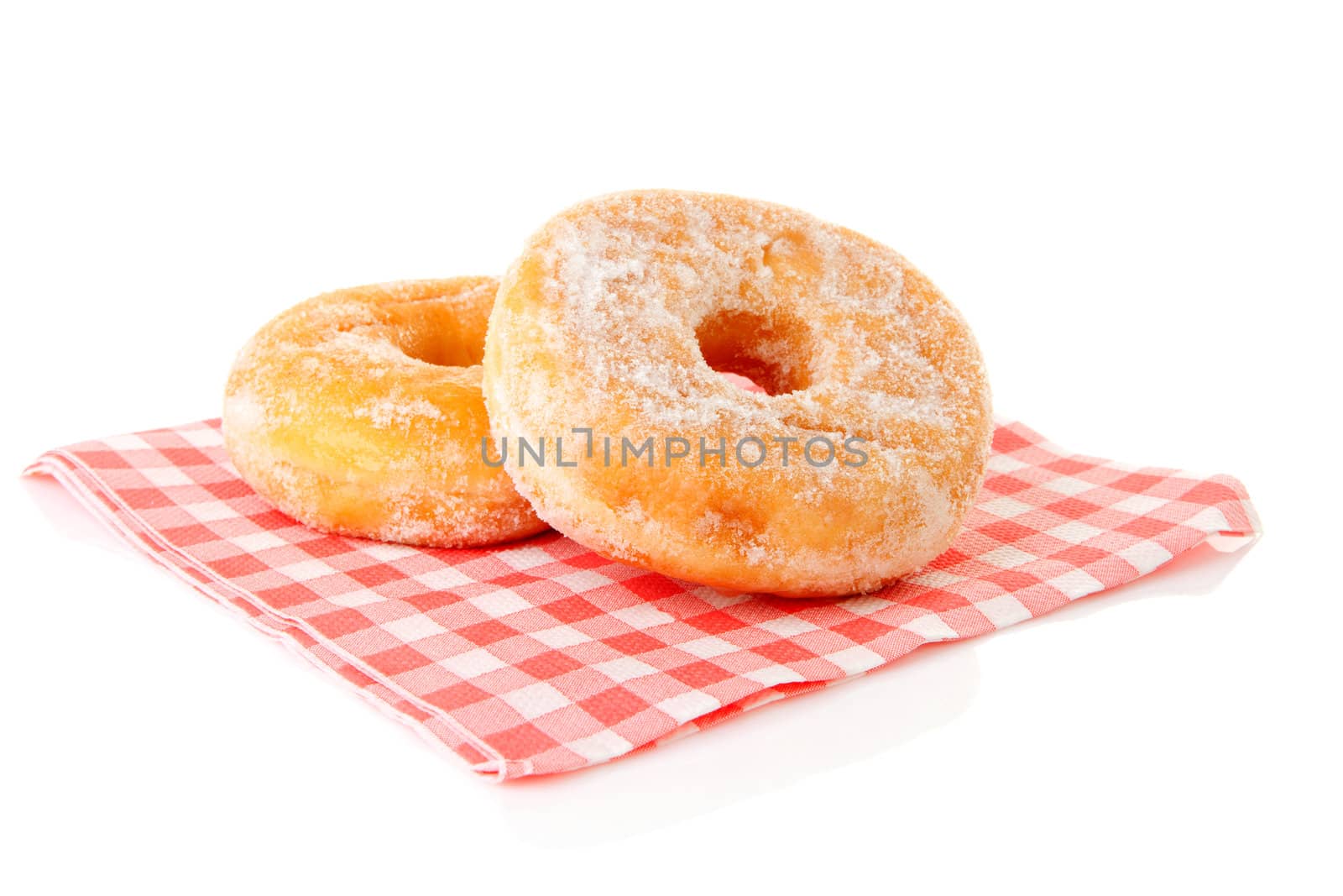 Two delicious sugared donuts on napkin over white background