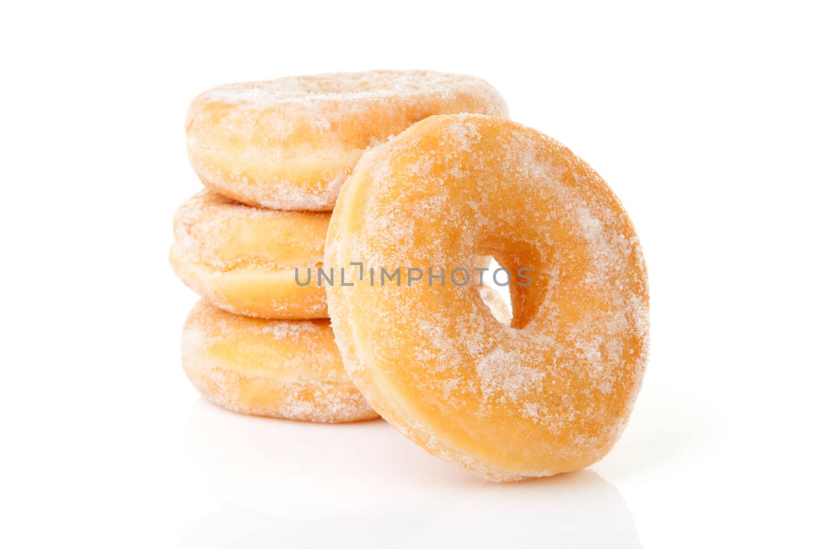 Stacked delicious sugared donuts over white background