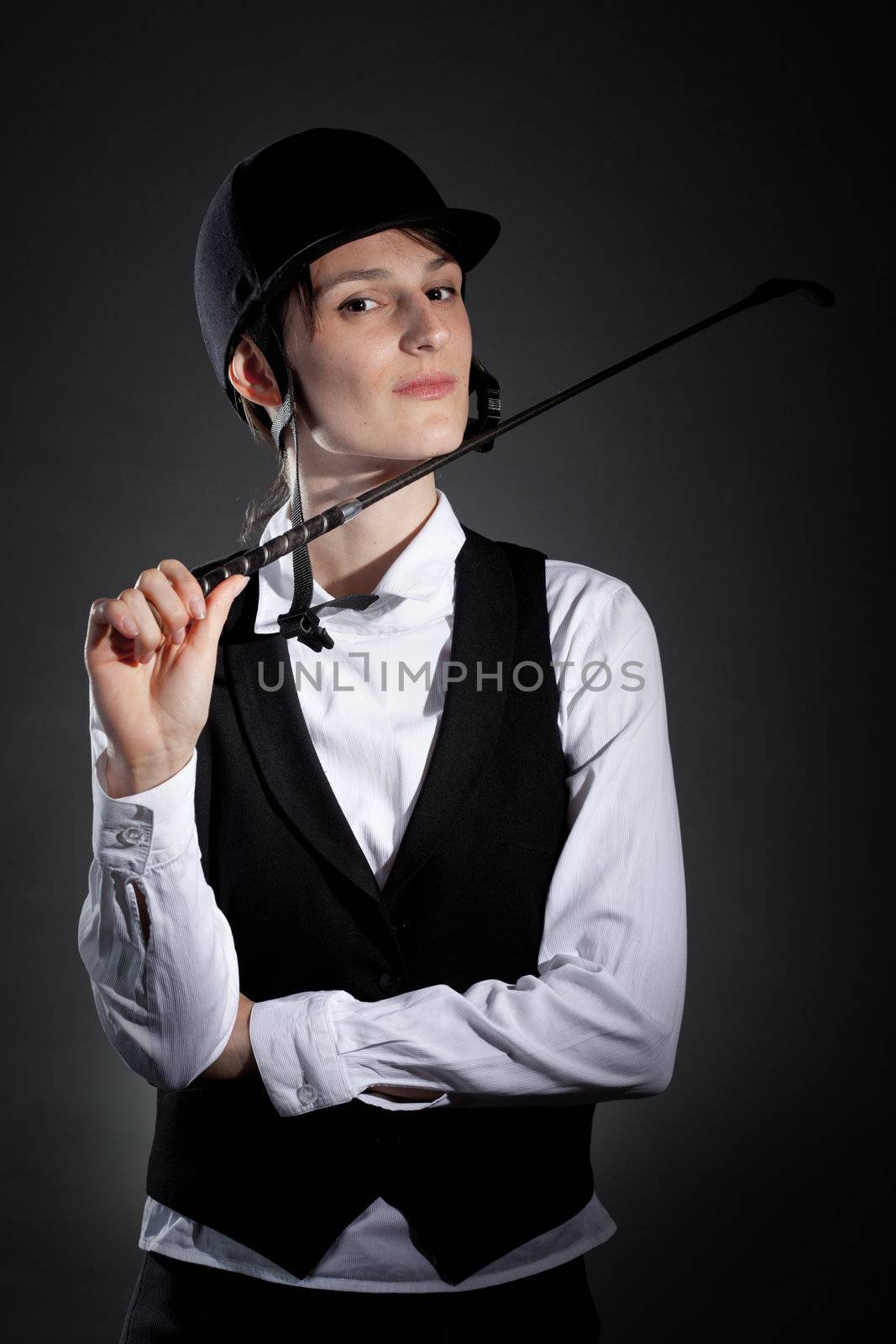 female horseback rider posing against black background