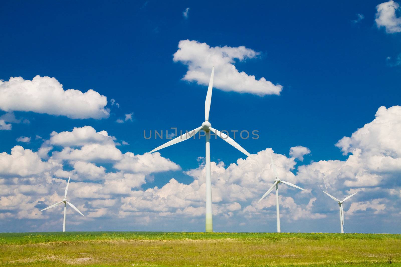 Windmills horizontal in a field, blue sky with clouds