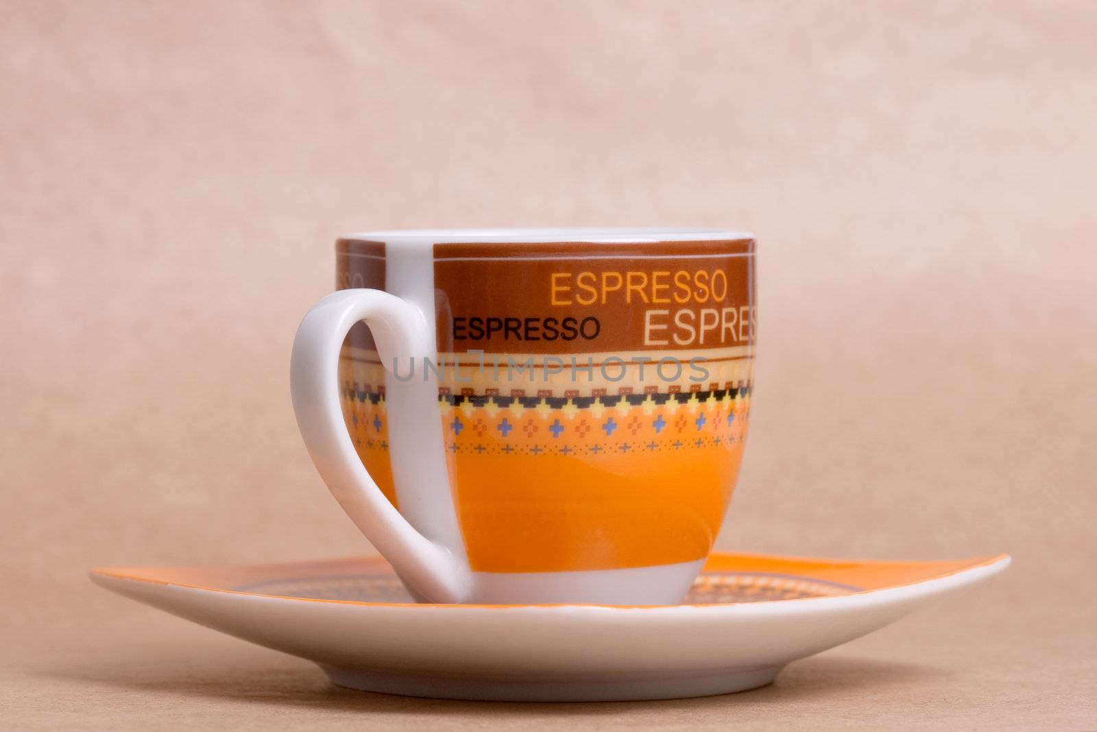 orange espresso cup on ochre background