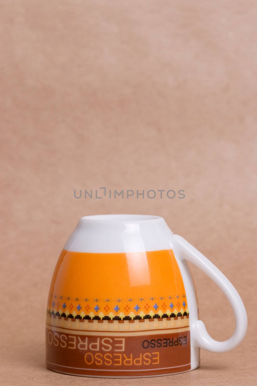 orange espresso cup on ochre background