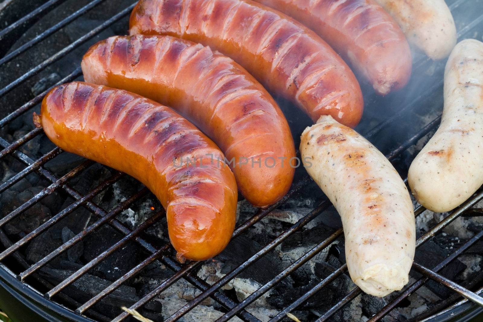 Closeup on grilled sliced sausages, tasty picnic food