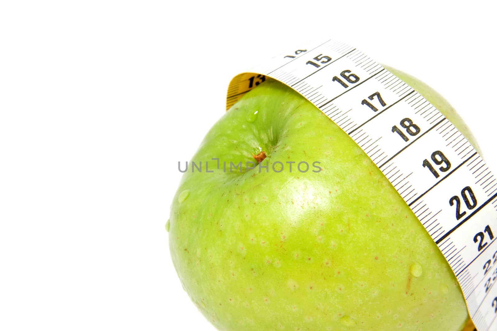 Green aplle with measure-tape isolated on white background