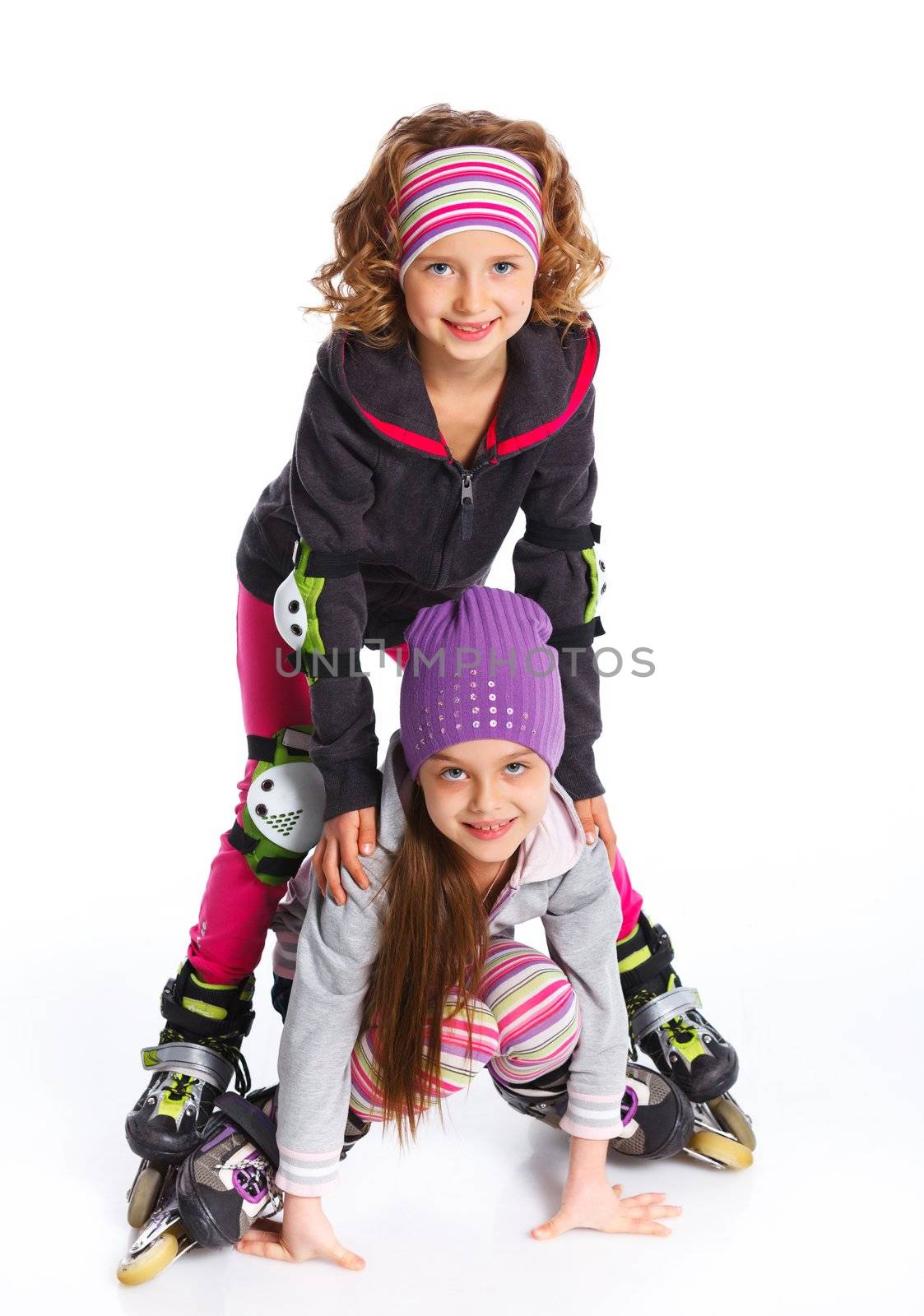 Two cute girls holding hands wearing roller skates. Isolated on a white background