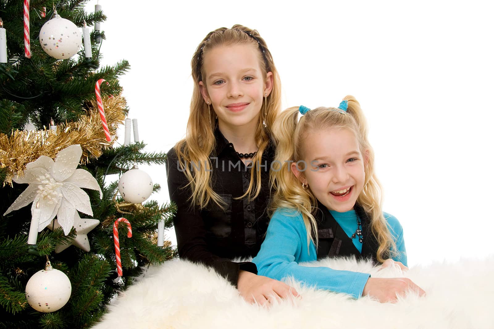Two children near christmas tree over white background
