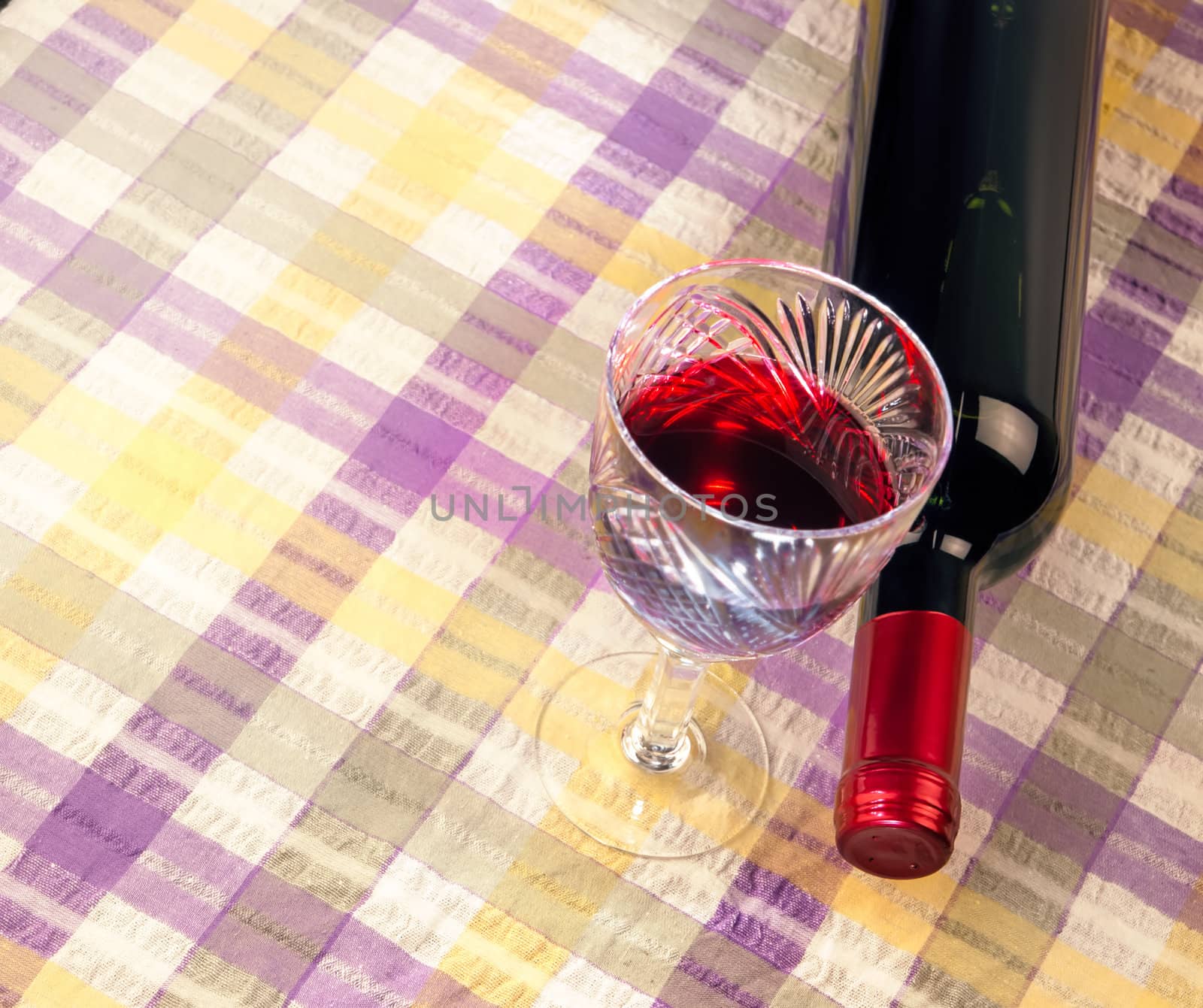 bottle of wine and a glass against a background of cloth by Zhukow