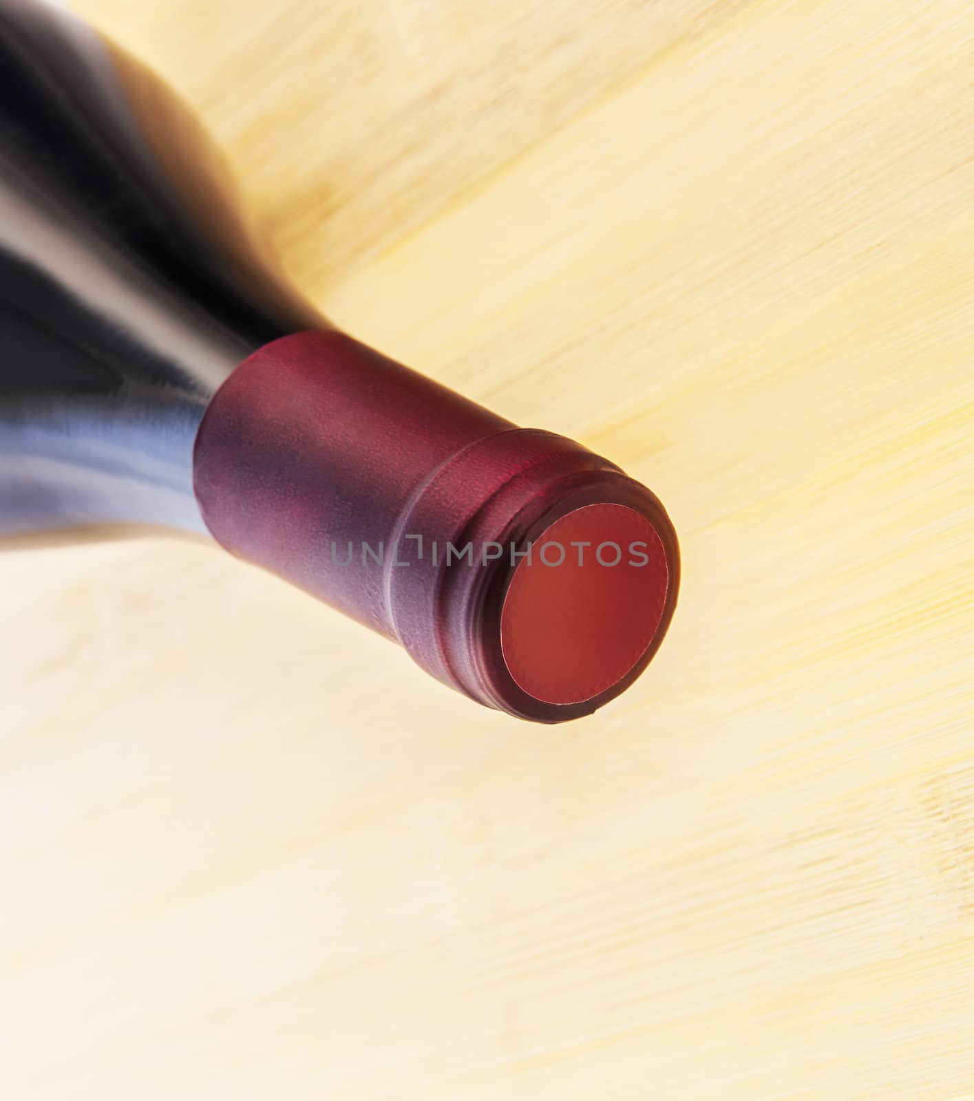 Red wine bottle on wooden table background