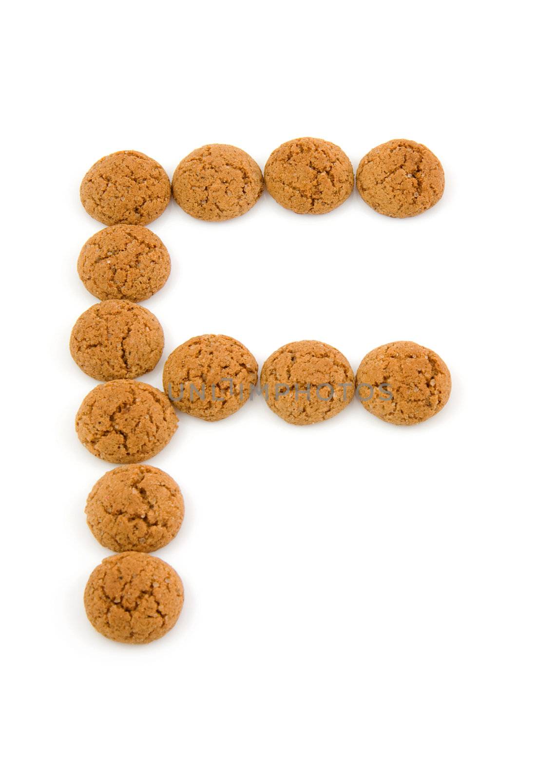Ginger nuts, pepernoten, in the shape of letter F isolated on white background. Typical Dutch candy for Sinterklaas event in december.