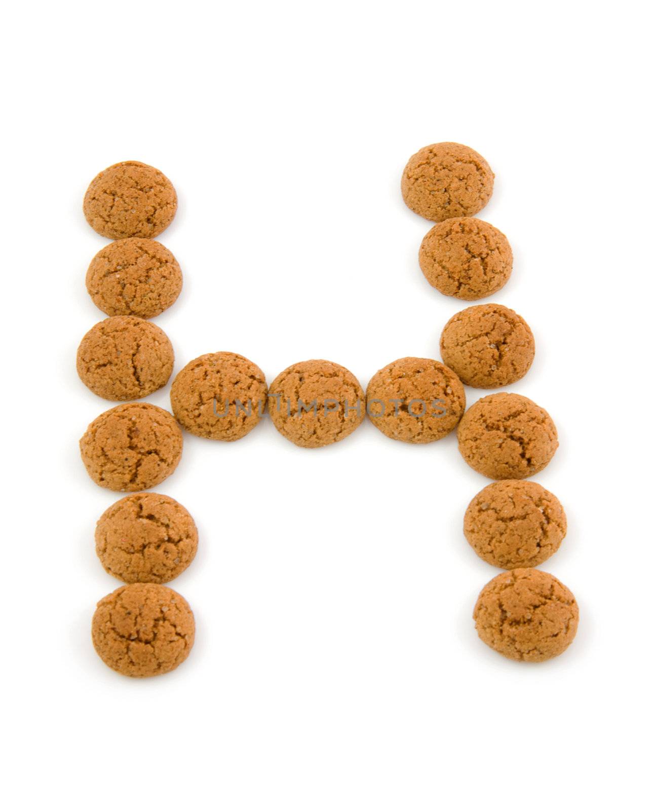 Ginger nuts, pepernoten, in the shape of letter H isolated on white background. Typical Dutch candy for Sinterklaas event in december.