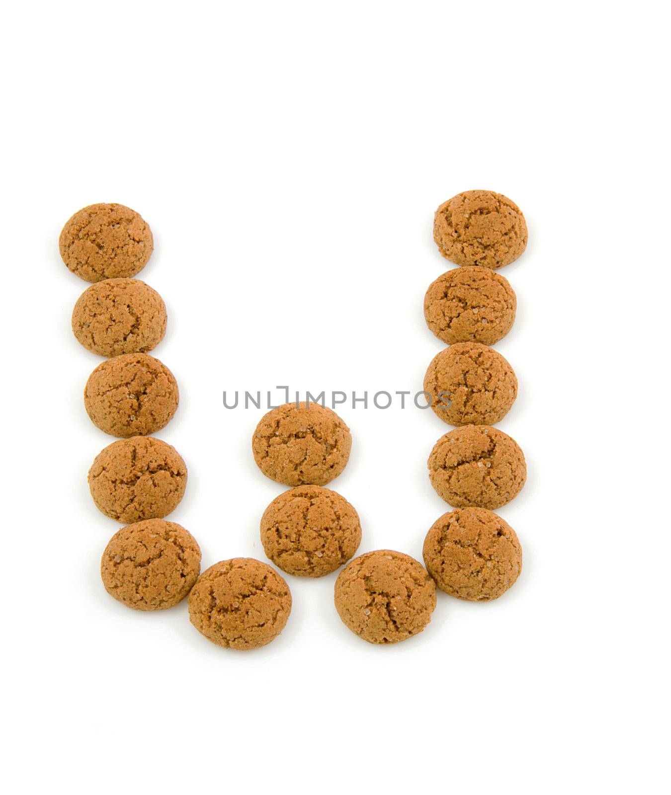Ginger nuts, pepernoten, in the shape of letter W isolated on white background. Typical Dutch candy for Sinterklaas event in december.
