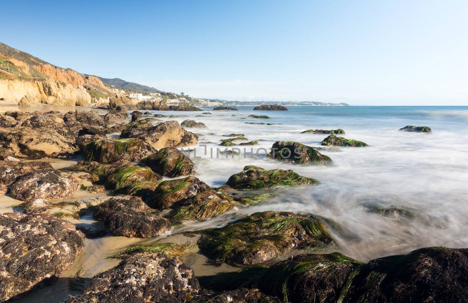 Seaweed covered rocks by ocean on El Matador State Beach Malibu California
