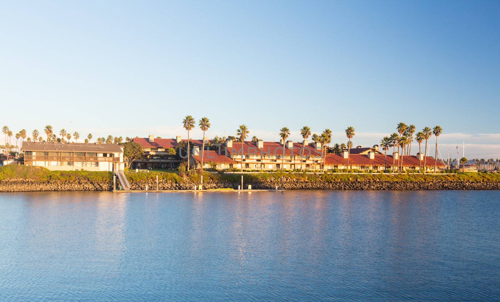 Sunset over timeshare development by water in Ventura California with modern homes and yachts boats