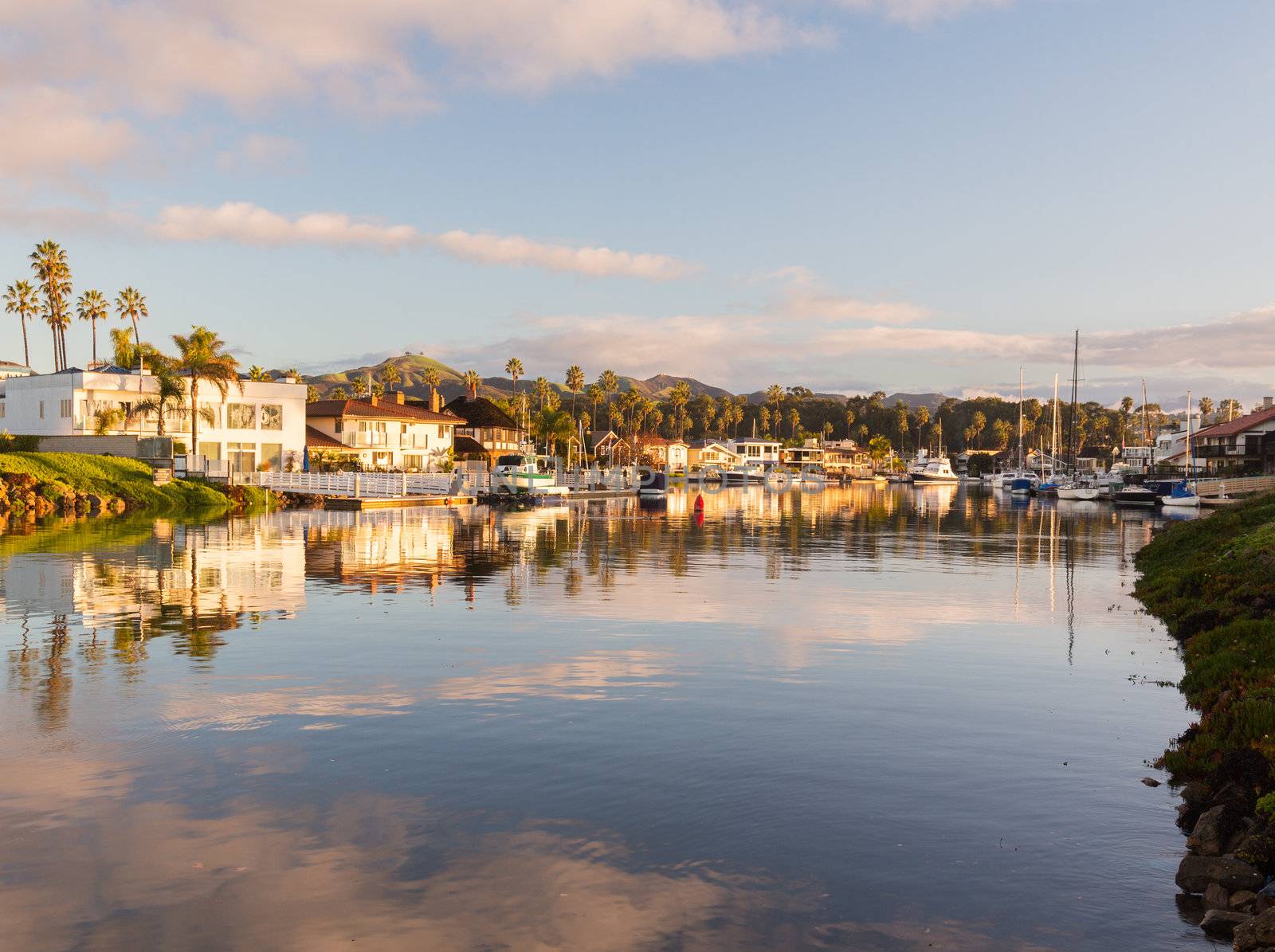 Sunrise at residential development by water in Ventura California with modern homes and yachts boats