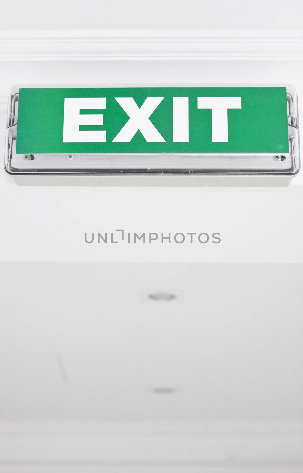 Green exit sign in ceiling. Space for text